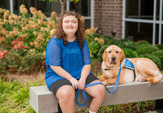 Chelsea and her service dog, Hector. He is a yellow lab.